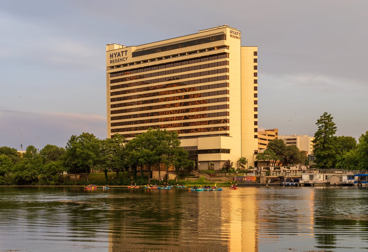 Luxury hotel on waterfront with city skyline and golden light