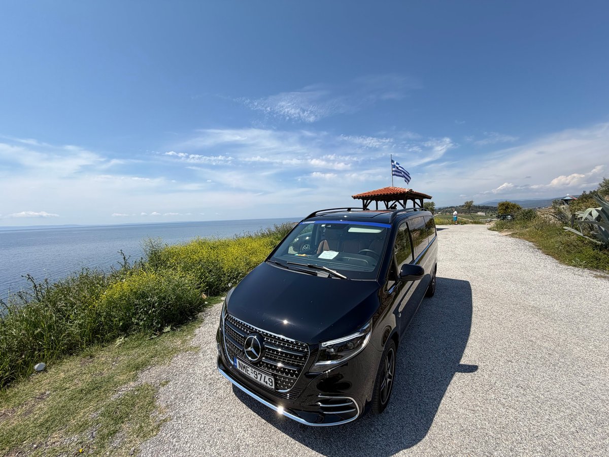 THE BLACK VAN SKG premium black vehicle on coastal road in Greece